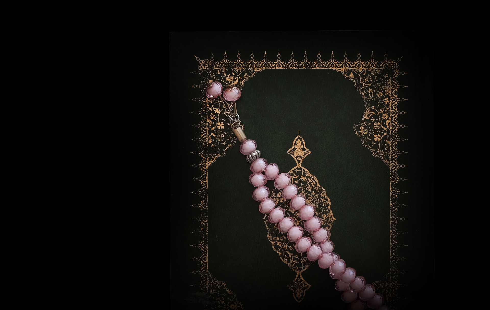 pink rosary on the holy Quran