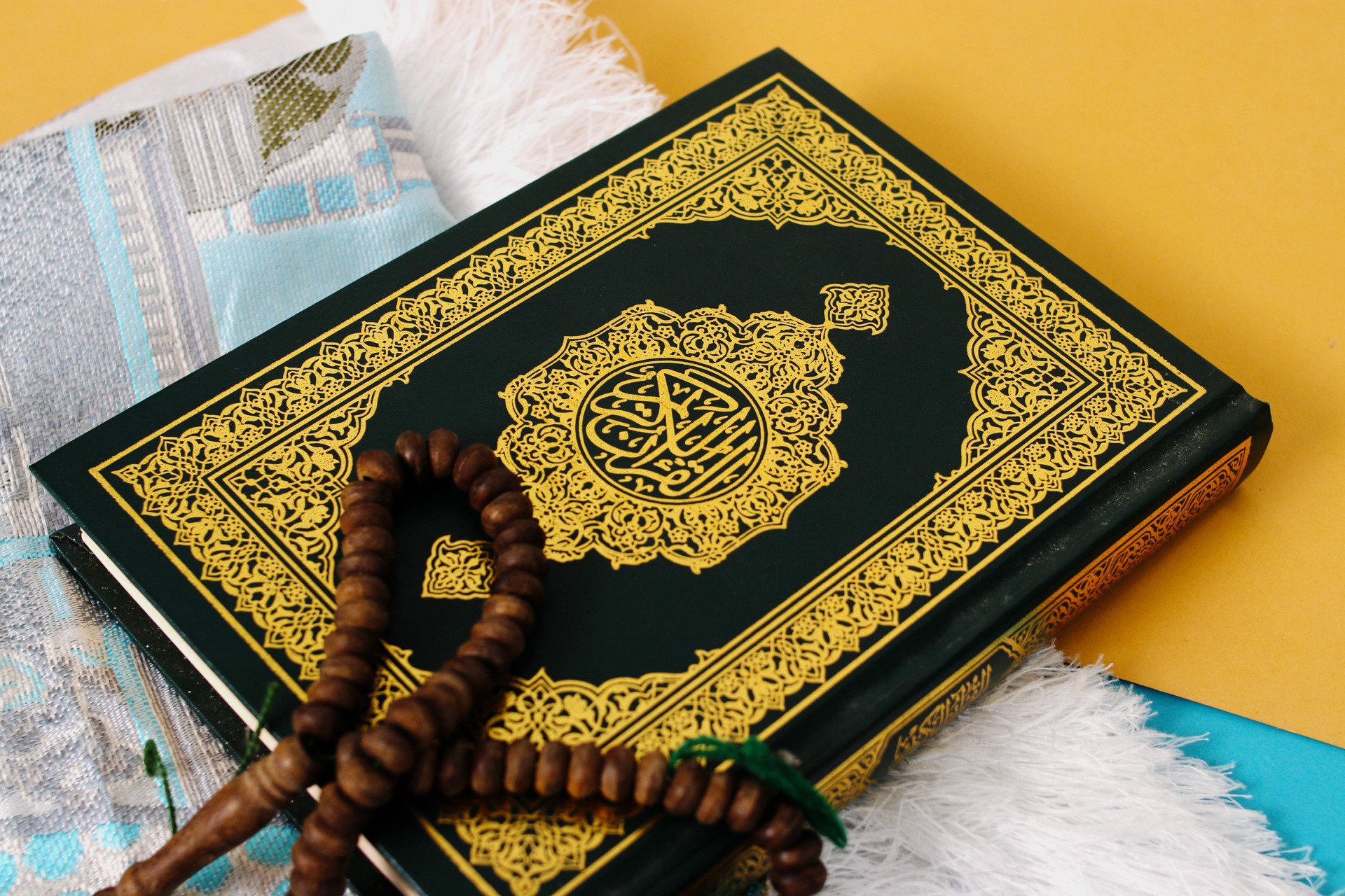 Ramadan Essentials, The Holy Quran, Prayer Mat, and Tasbih on Blue and Yellow